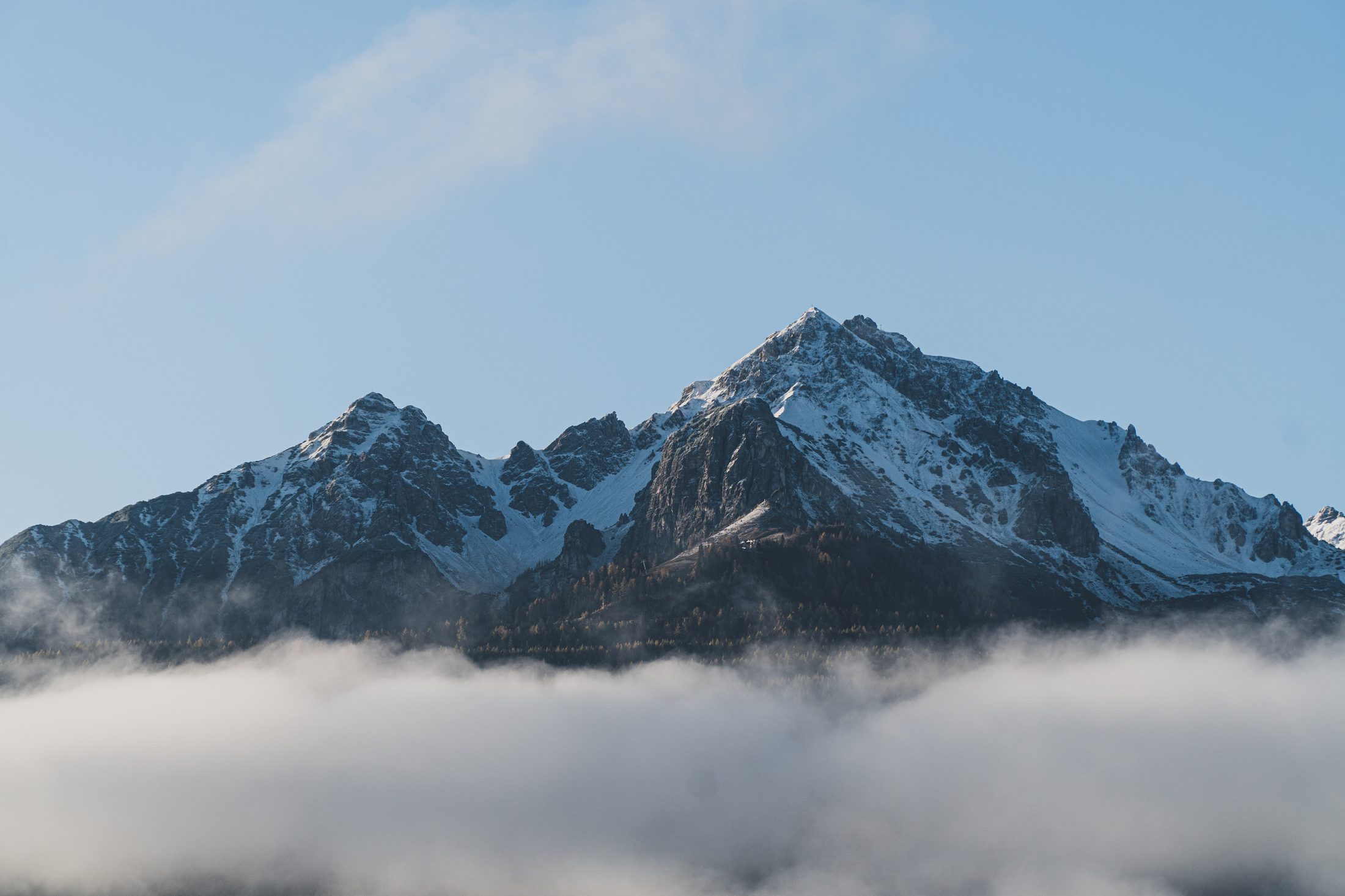 A snowy mountain ridge under moving cloud